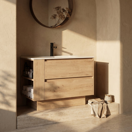 36" wall-mounted bathroom vanity in light wood with drawer and open shelf, white countertop and sink, beige wall, round mirror with dried flower décor, beige flooring, and folded towels on a ledge.