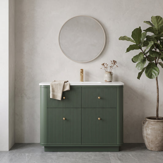 Green wall-mounted vanity with white countertop and gold faucet in a minimalistic bathroom setting.
