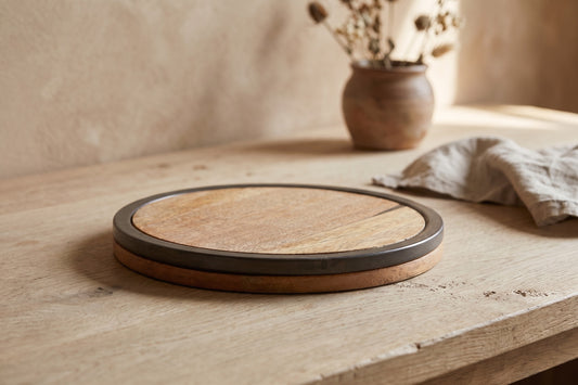 Round trivet with wooden center and concrete edge on a wooden table
