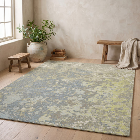 Abstract patterned rug in green and grey on wooden floor, minimalist decor, no visible text.