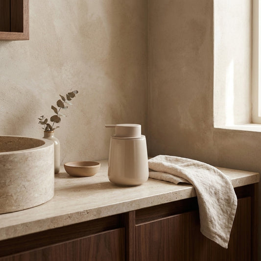 Large beige recycled ceramic foaming soap dispenser on a beige countertop in a serene bathroom setting