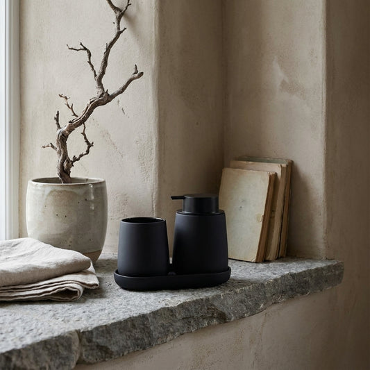 Black matte rubber painted bathroom accessories set on a stone ledge.