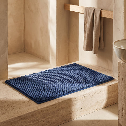 Blue Chenille bath mat on beige stone steps.