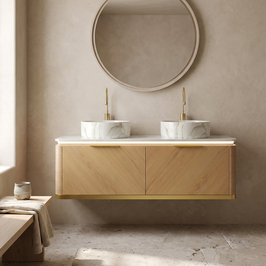 Floating wooden bathroom vanity with marble sinks and gold fixtures, light wood finish, neutral tones, minimalist beige wall, circular mirror above