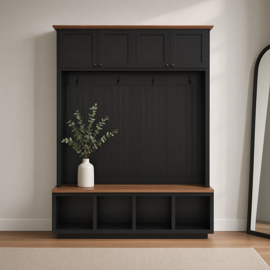 An entryway hall tree with black cabinets, wooden bench, and open cubbies, adorned with a vase of greenery, set on a light floor with a rug and a partial view of a mirror in the background.