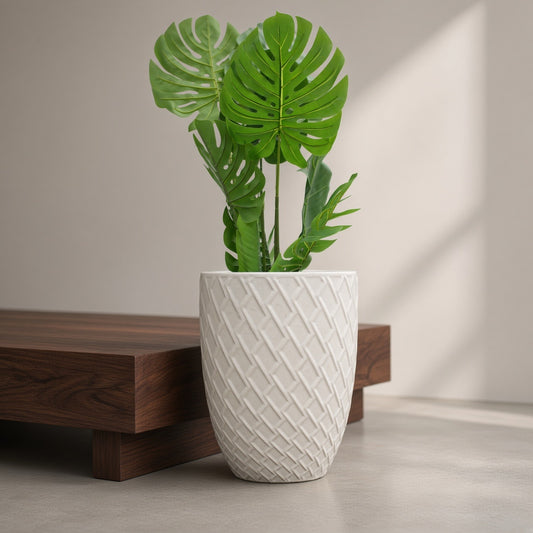 17-inch white ceramic planter with textured weave pattern featuring a green Monstera plant with a wooden bench and soft shadow in background.