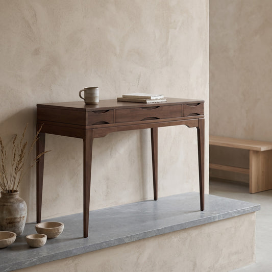 Harper 48" Wide Solid Hardwood Mid-Century Modern Small Desk with a dark finish displayed on a concrete surface, neutral background, and decor items nearby.