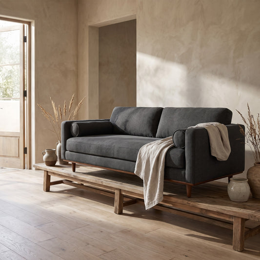 Framed sofa and ottoman set, dark gray upholstery, wooden base, minimalist decor, wooden floor, natural light, clean design