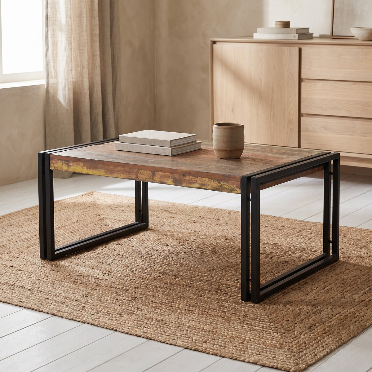Old reclaimed wood coffee table with black steel frame base in a bright living room
