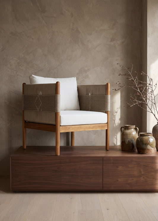 Outdoor Acacia Wood Club Chair with White Cushions, Light Brown Wood Finish, placed on a wooden bench in a minimalistic room with simple decor and earthenware jars.