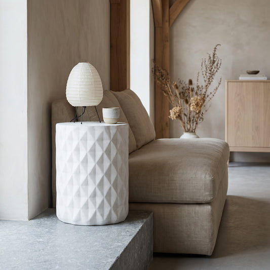 Antique white concrete side table with diamond texture in a minimalist living room