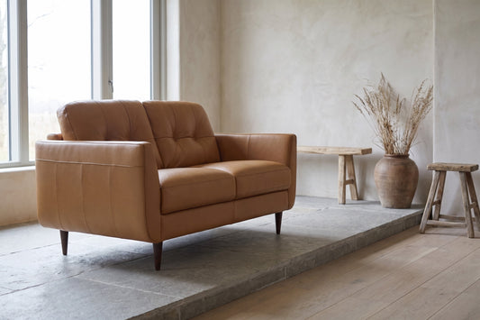 Radwan Camel Leather Loveseat with tufted design in a minimalistic interior.