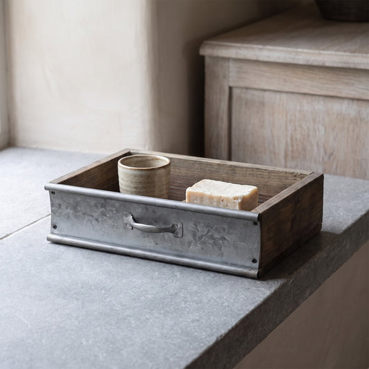 Rustic wood and metal tray with ceramic object and bar soap.
