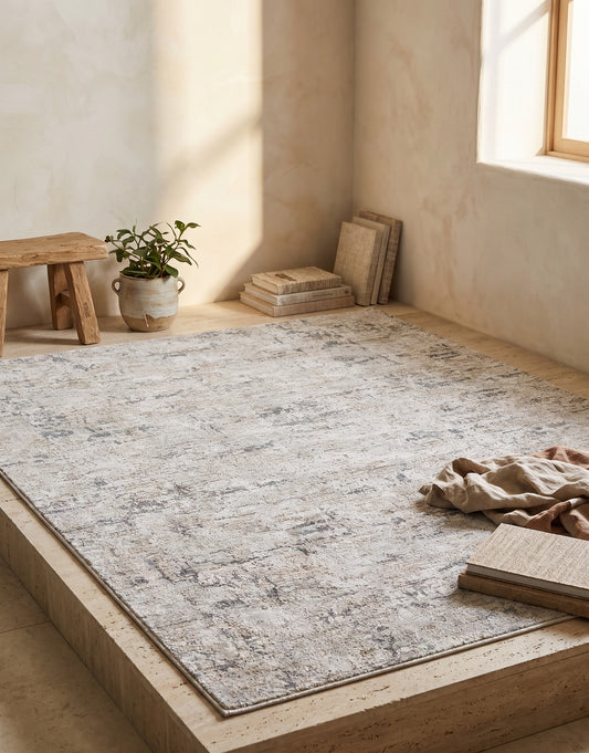 Large rug with rustic, distressed pattern on light brown surface, soft wall and natural light.