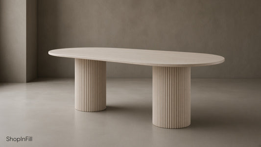 Oval dining table made of light stone with fluted legs, set in minimalist space