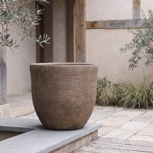 Textured ceramic planter on stone ledge