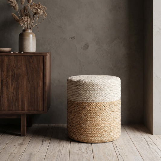 White Jute Round Pouffe Stool with beige jute base and painted top, positioned in a minimalist setting with a wooden cabinet and vase of dried flowers.