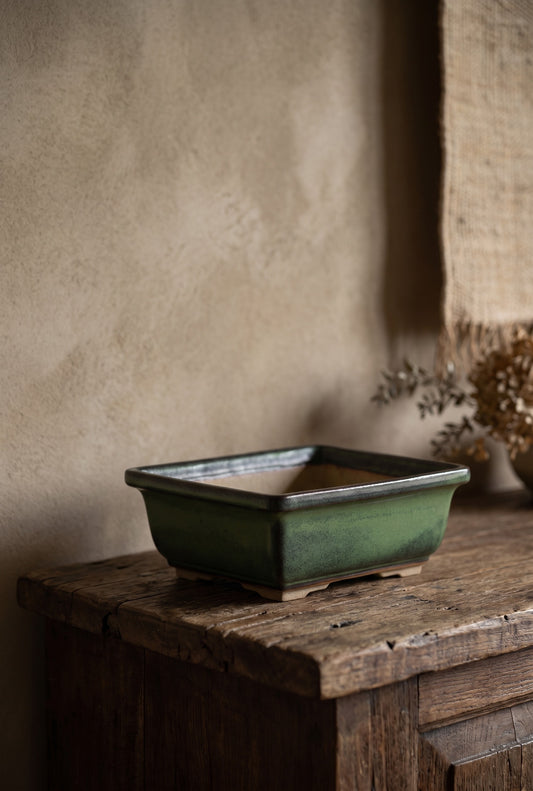 Square ceramic bonsai pot on wooden bench