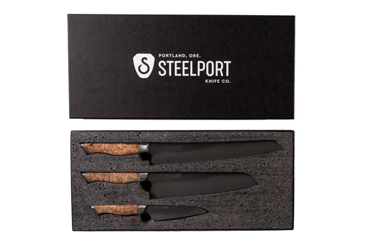 3 metal knives with wooden handles in a black box with 'Steelport Knife Co.' logo, black background.