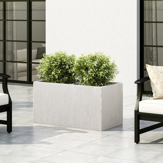 Concrete rectangular planter box with two shrubs on a tiled patio.